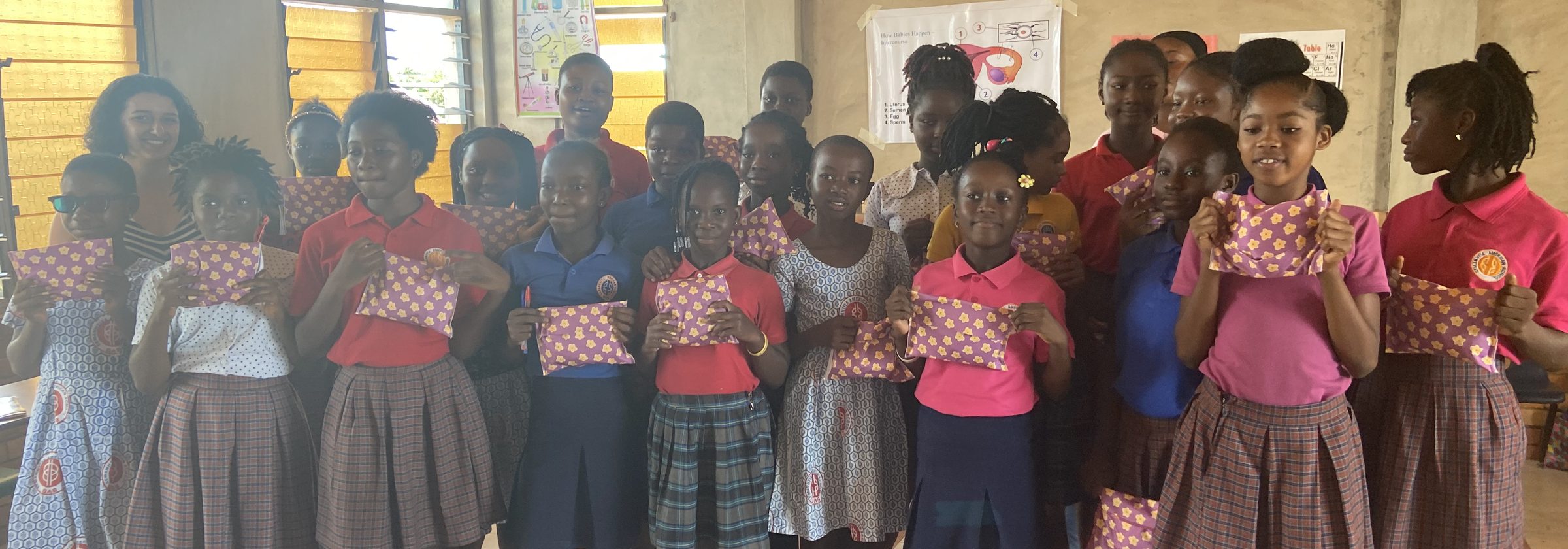 Students in Senase, Ghana, holding their reusable menstrual kits