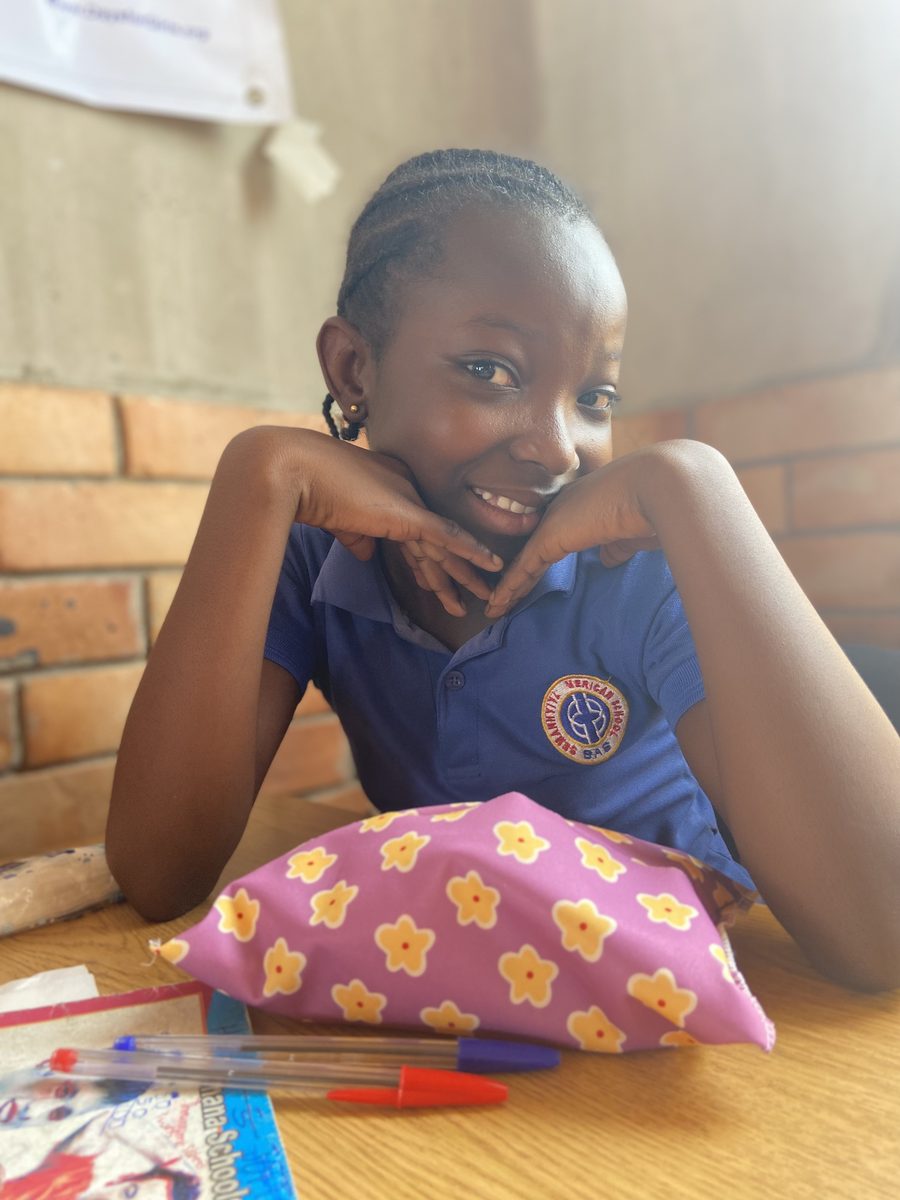 A student in Senase smiling with her reusable menstrual kit
